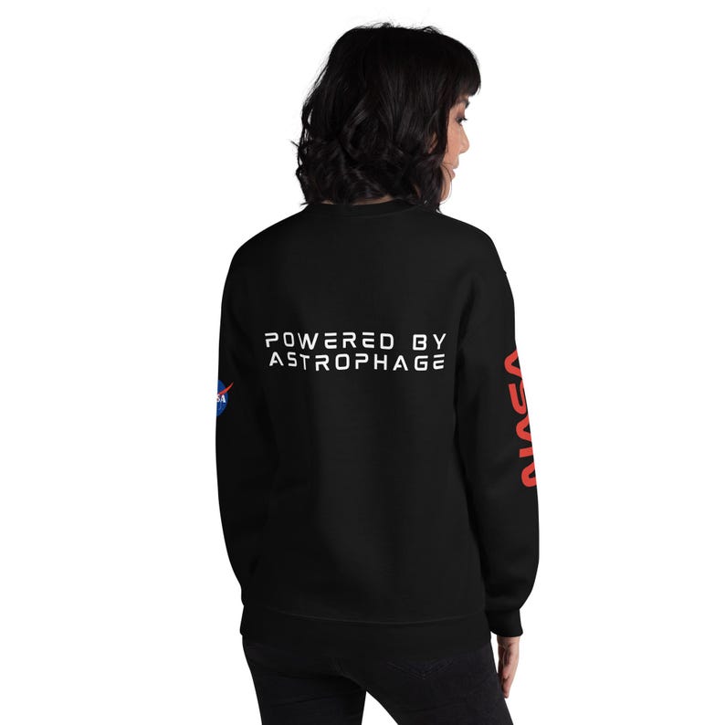 May include: Black sweatshirt with the text "POWERED BY ASTROPHAGE" in white on the back. The NASA logo is on the left sleeve, and the word "NASA" is printed in red on the right sleeve. A casual, comfortable garment.