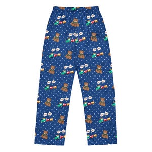 May include: Blue pajama trousers with a repeating pattern of brown teddy bears, green and red toy trains, and white polka dots. The bears have brown fur and wear green bows. The trains have red, yellow, and green carriages.
