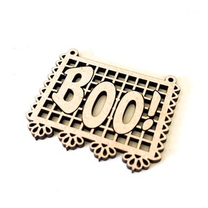 Puede incluir: Un recorte de madera de una pancarta con la palabra "BOO!" en negrita. La pancarta tiene un borde decorativo y un patrón de celosía.