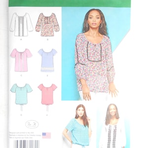 May include: A Simplicity 1162 sewing pattern envelope for a blouse with a scoop neckline and various sleeve lengths. The package displays illustrations of six different blouse variations, including floral and solid colors, in U.S. sizes 14-22.