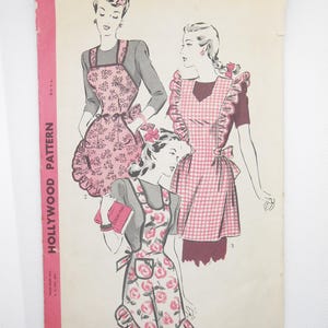 May include: Vintage sewing pattern for three different aprons. The aprons are pink and white with floral and gingham patterns. The pattern is labeled "Hollywood Pattern" and includes instructions for a "sew-simple design".