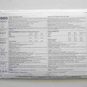 May include: A white paper pattern envelope for Misses' Patchwork Aprons, featuring diagrams of apron designs. The envelope includes size charts and fabric requirements. The pattern is labeled "2980" and includes 15 pieces.