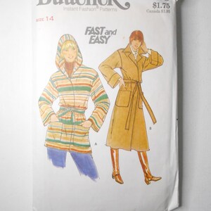 May include: A vintage Butterick sewing pattern, size 14, featuring illustrations of two coat designs. One coat is a hooded, striped design, and the other is a belted trench coat. The pattern is labeled "FAST and EASY."