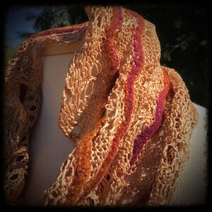 May include: A crocheted scarf with a brown and orange base and a purple and orange stripe pattern.