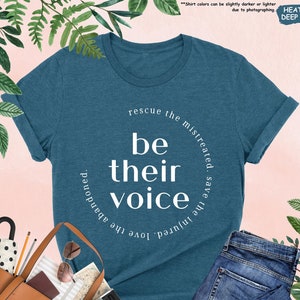 a t - shirt that says be their voice surrounded by shoes and handbags