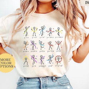 May include: An ivory t-shirt featuring a graphic print of fifteen stick figures, each posed to represent a different mathematical function with its corresponding equation, such as y=x, y=x², y=sin x, y=tan x, and x²+y²=a². The design uses colorful lines.