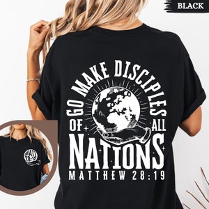 May include: Black t-shirt with a white graphic design featuring a hand holding a globe with the text "Go Make Disciples of All Nations Matthew 28:19".