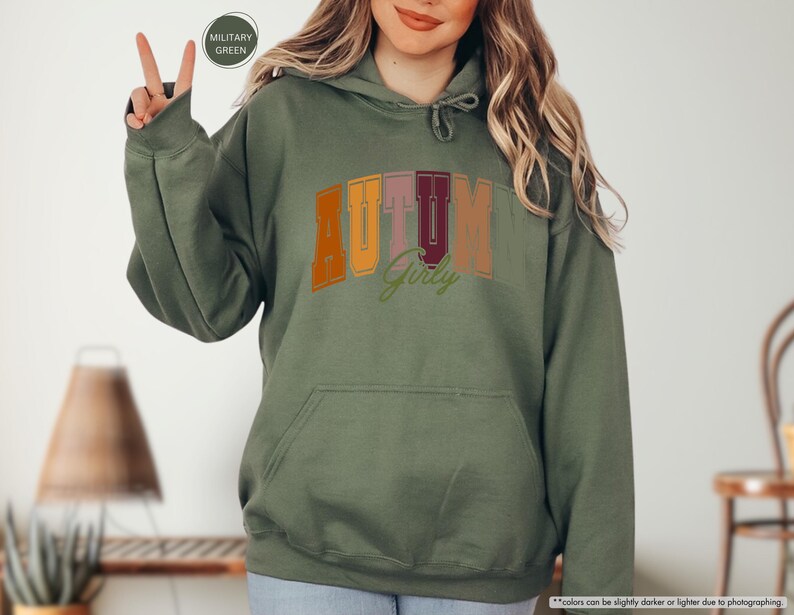 a woman in a green hoodie holding up a peace sign