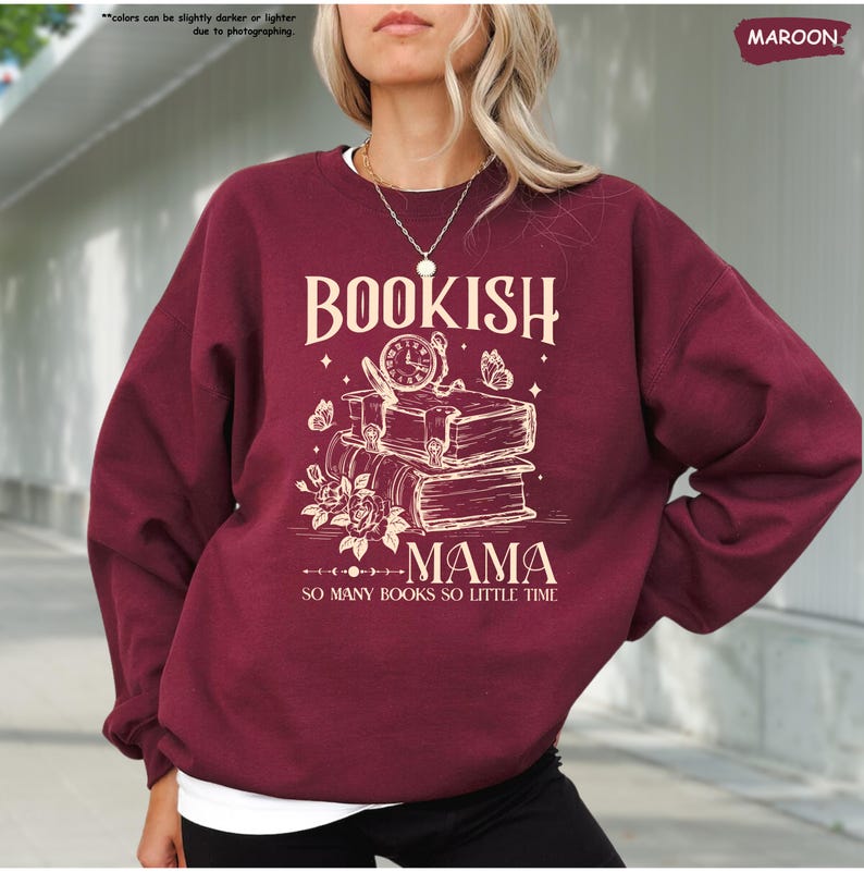 May include: Maroon sweatshirt with the text "BOOKISH MAMA" and the phrase "SO MANY BOOKS SO LITTLE TIME". The design features stacked books, a clock, butterflies, and flowers in a cream color.