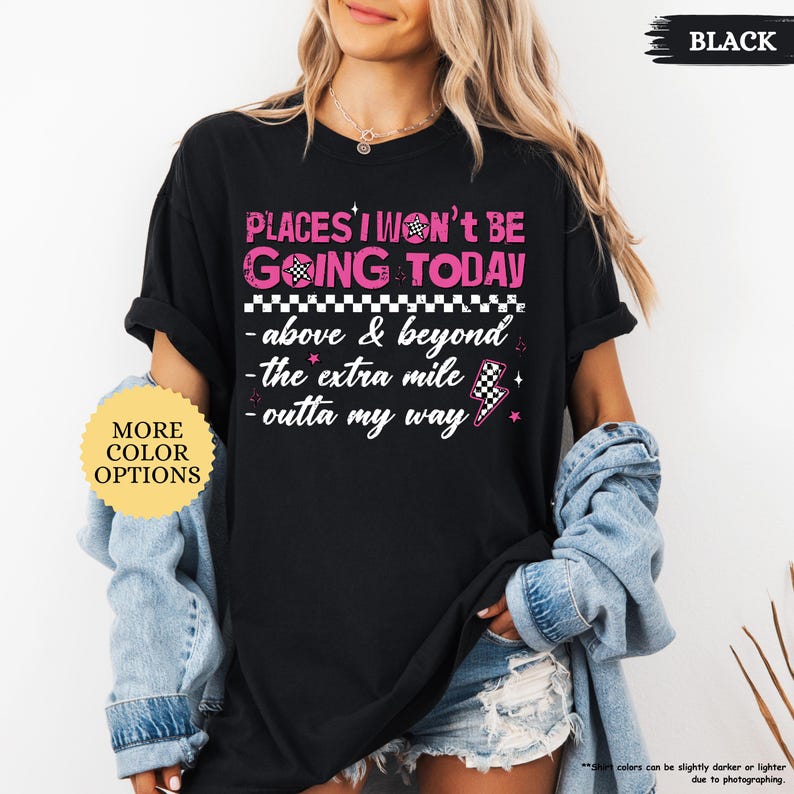 May include: Black t-shirt with the text "PLACES I WON'T BE GOING TODAY" in pink and white. The shirt also features the phrases "above & beyond", "the extra mile", and "outta my way". A button on the left says "MORE COLOR OPTIONS".
