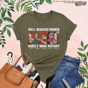 May include: Green t-shirt with a graphic of five women's faces and the text "Well-behaved women rarely make history". The women's faces are surrounded by words like "fight", "like", "rise", and "power".