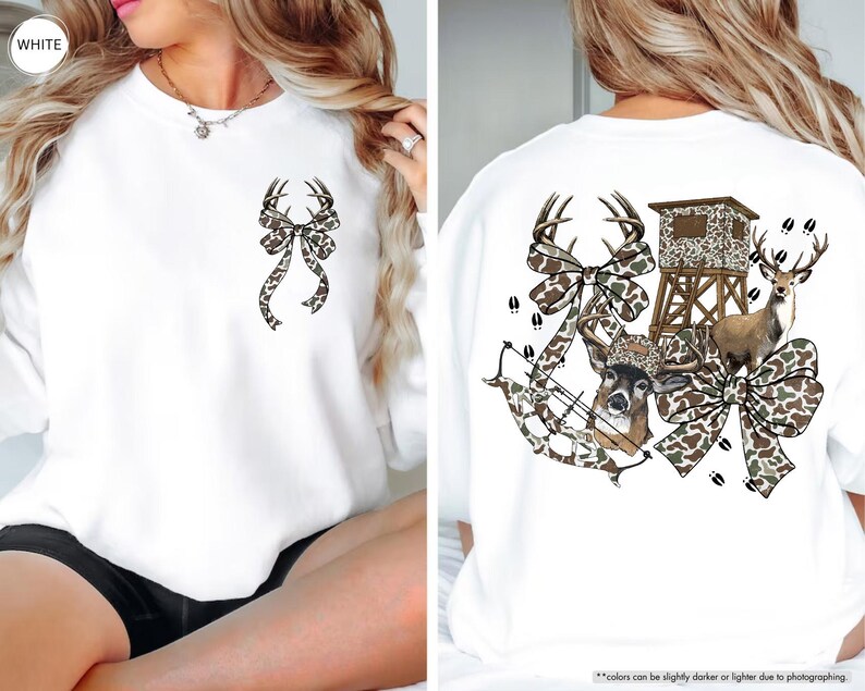 May include: White sweatshirt with a deer antler bow design on the front and back. The back features a deer, hunting blind, bow and arrow, and deer tracks, all in a camouflage pattern.