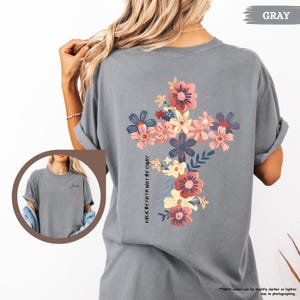 May include: Gray t-shirt with a floral cross design and the text "WALK BY FAITH NOT BY SIGHT".