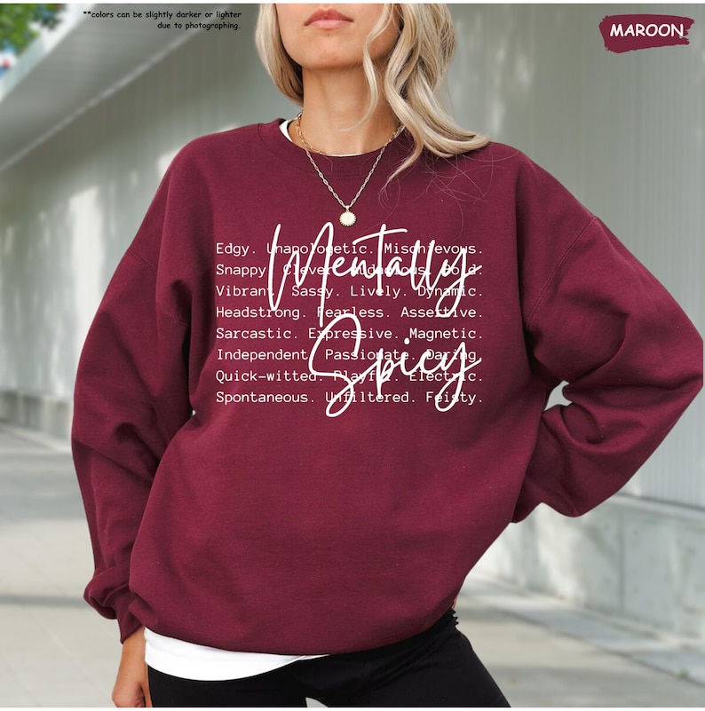 K&ouml;nnte beinhalten: Burgunderfarbenes Sweatshirt mit dem Schriftzug "Mentally Spicy" in wei&szlig;er Schrift. Das Design enth&auml;lt eine Liste von Adjektiven wie "Edgy", "Snappy" und "Sarcastic". Das Sweatshirt ist einfarbig und hat einen Rundhalsausschnitt.