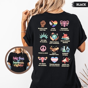 May include: Black t-shirt with various social justice graphics, including a raised fist, a rainbow heart, and the text "Black Lives Matter." The shirt also features the text "big fan of human rights."