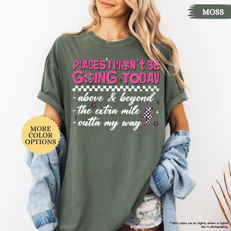 May include: Moss green t-shirt with the text "PLACES I WON'T BE GOING TODAY" in pink and white. The shirt also features the phrases "above & beyond", "the extra mile", and "outta my way". A button on the left says "MORE COLOR OPTIONS".