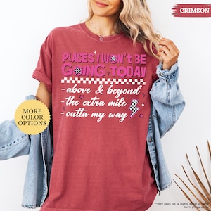 May include: Crimson-colored t-shirt with the text "PLACES I WON'T BE GOING TODAY" in pink and black. The shirt features additional text: "above & beyond", "the extra mile", and "outta my way". A "More Color Options" button is visible.