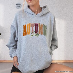 a woman sitting on the floor wearing a hoodie