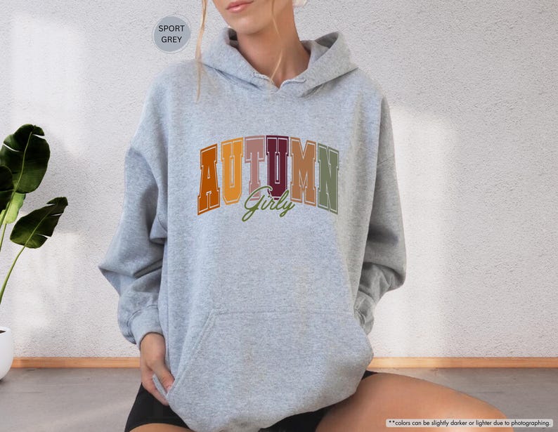 a woman sitting on the floor wearing a hoodie