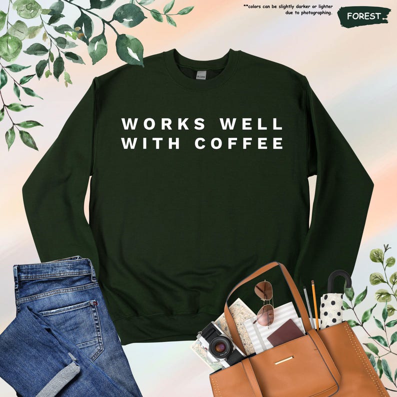May include: A dark green sweatshirt with the text "WORKS WELL WITH COFFEE" in white lettering.