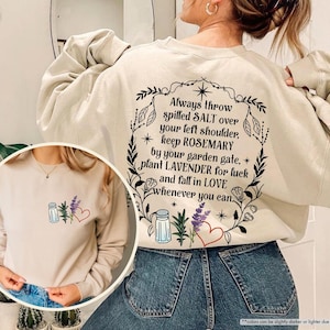 May include: A beige sweatshirt with a graphic print on the back that reads "Always throw spilled SALT over your left shoulder, keep ROSEMARY by your garden gate, plant LAVENDER for luck and fall in LOVE whenever you can."