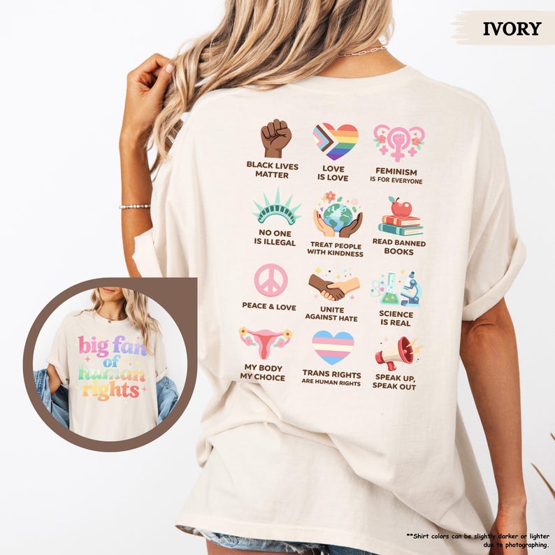 May include: Ivory-colored t-shirt with the text "big fan of human rights" and various graphic symbols representing social justice and equality. The back of the shirt features additional icons and phrases like "Black Lives Matter" and "Love is Love."