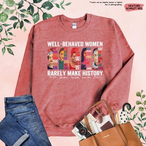 May include: Heather scarlet red sweatshirt with a graphic print of famous women and the text "Well-behaved women rarely make history".