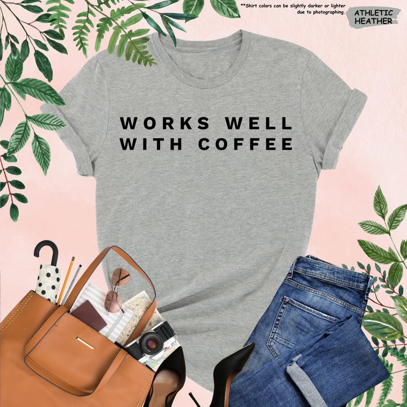 May include: A heather grey t-shirt with the text "WORKS WELL WITH COFFEE" printed in black.