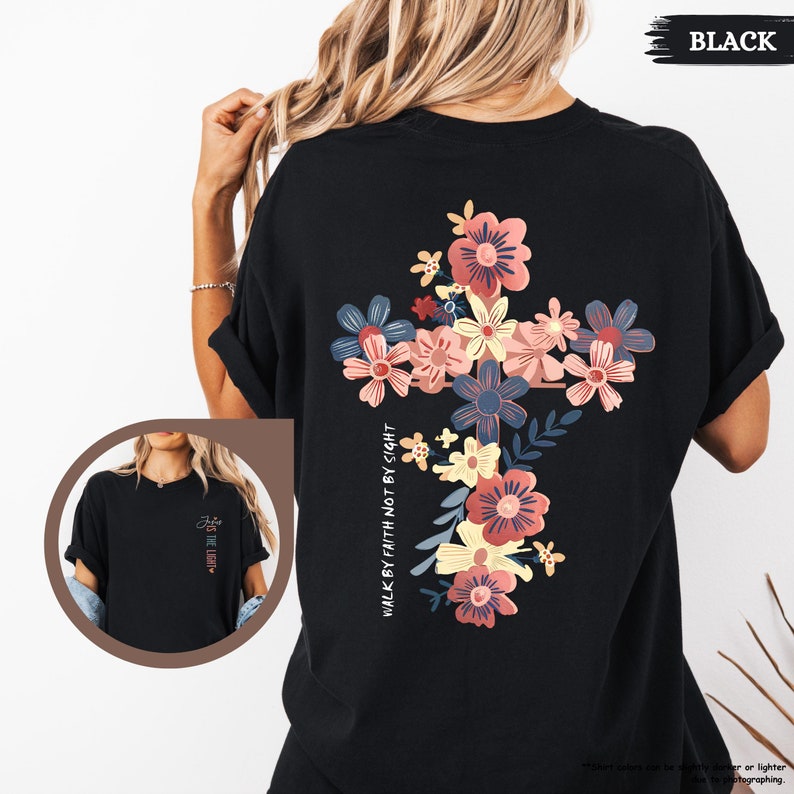 May include: Black t-shirt with a floral cross design and the text "Walk by faith not by sight".