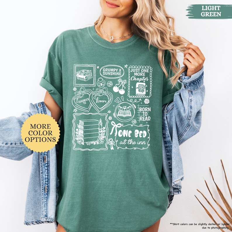Puede incluir: Camiseta verde claro con un dise&ntilde;o gr&aacute;fico blanco que presenta ilustraciones y texto con tem&aacute;tica de libros. El dise&ntilde;o incluye las frases "Grumpy x Sunshine", "Enemies to Lovers", "Just One More Chapter" y "One Bed at the Inn".