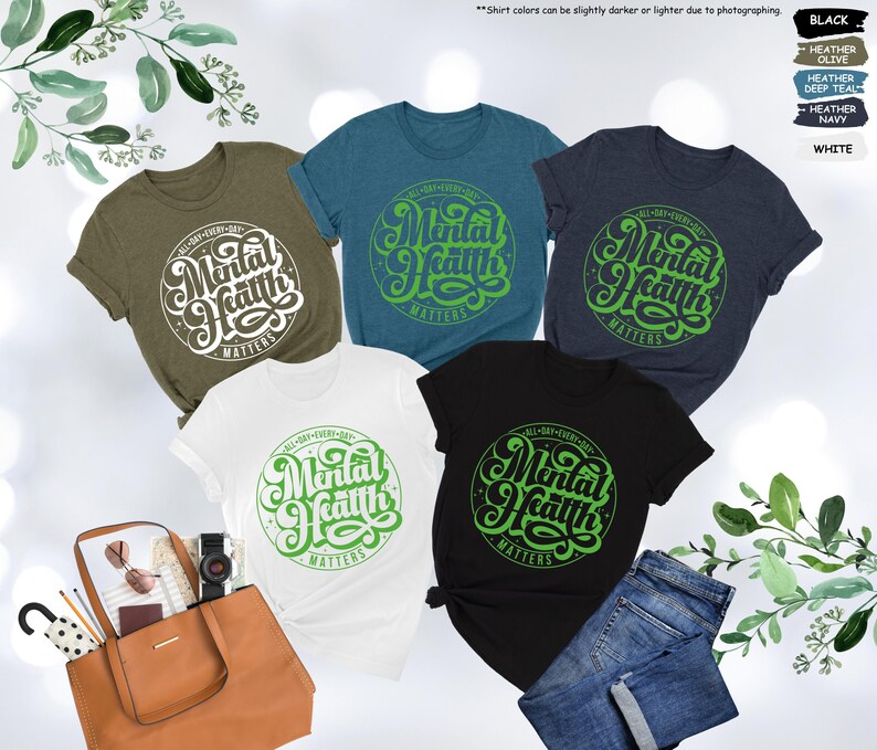 May include: Five t-shirts in different colors with the text "Mental Health Matters" in a green and white design. The text is in a circle with a starburst pattern.