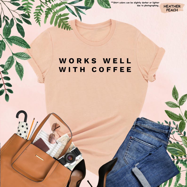 May include: A peach colored t-shirt with the text "WORKS WELL WITH COFFEE" printed in black.