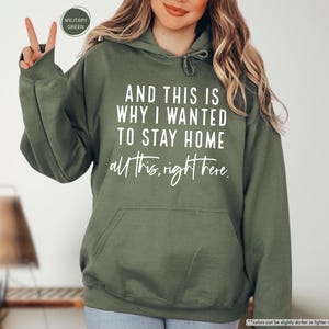 K&ouml;nnte beinhalten: Ein gr&uuml;ner Kapuzenpullover mit dem Aufdruck "AND THIS IS WHY I WANTED TO STAY HOME all this right here." in wei&szlig;.