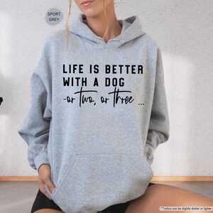 May include: A gray hooded sweatshirt with the text "Life is better with a dog - or two, or three..." printed in black.