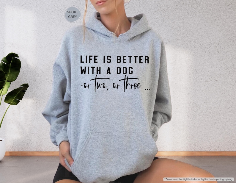 May include: A gray hooded sweatshirt with the text "Life is better with a dog - or two, or three..." printed in black.