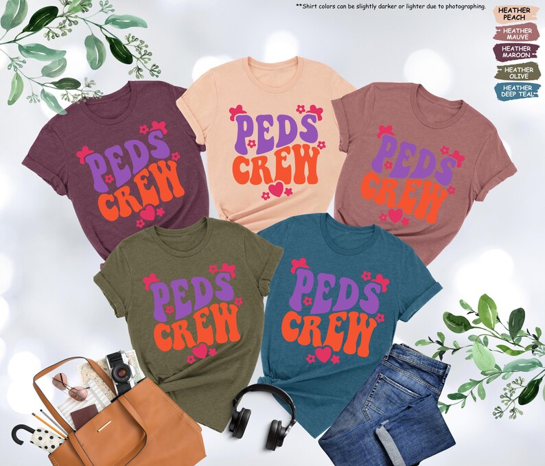 May include: Five t-shirts in different colors with the text "PEDS CREW" in a retro font. The text is in purple and orange with pink hearts and flowers.