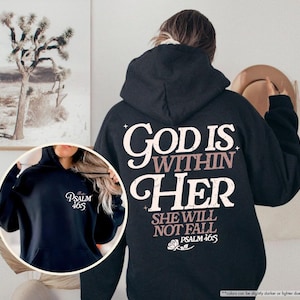 Puede incluir: Sudadera con capucha negra con el texto "GOD IS WITHIN HER SHE WILL NOT FALL PSALM 46:5" en letras blancas y malva. Una imagen m&aacute;s peque&ntilde;a muestra una sudadera con capucha azul marino con "PSALM 46:5" impreso.