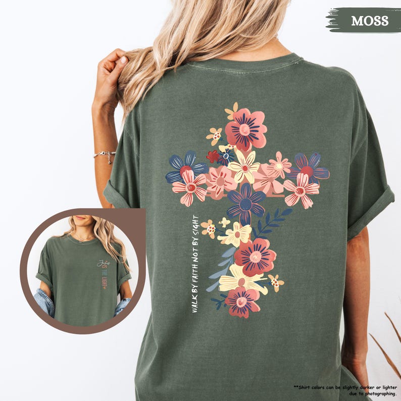 May include: A moss green t-shirt with a floral cross design and the text "Walk by faith not by sight".