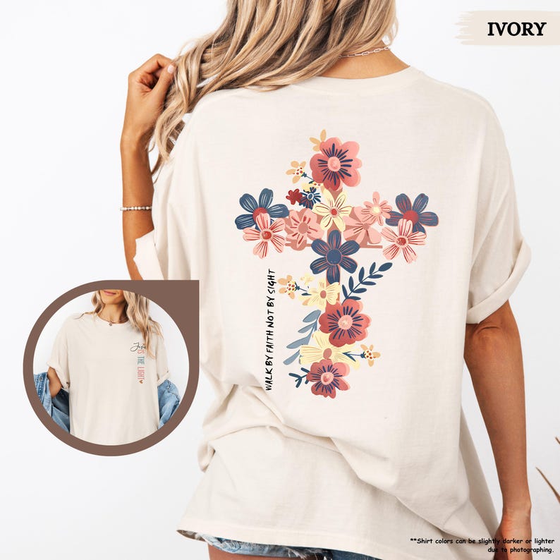 May include: Ivory t-shirt with a floral cross design and the text "Walk by faith not by sight".