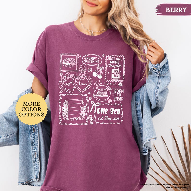 Puede incluir: Camiseta de color bayas con dise&ntilde;os gr&aacute;ficos blancos que incluyen libros, corazones y el texto "Grumpy x Sunshine", "Just One More Chapter" y "One Bed at the Inn". Incluye un bot&oacute;n "More Color Options".