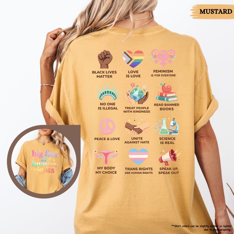 May include: Mustard-colored t-shirt with various graphic icons and text, including "Black Lives Matter," "Love is Love," and "Feminism is for Everyone." Other phrases include "No One is Illegal," "Treat People with Kindness," and "Read Banned Books."