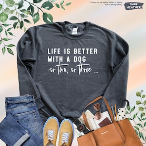 May include: A dark heather grey sweatshirt with the text "LIFE IS BETTER WITH A DOG -or two, or three..." printed in white on the front.