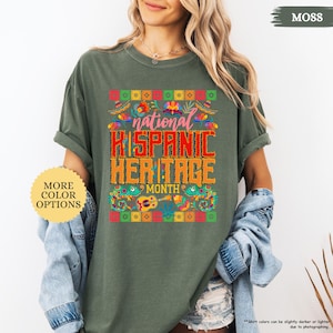 Peut inclure: T-shirt vert mousse avec un graphisme color&eacute; c&eacute;l&eacute;brant le Mois national du patrimoine hispanique. Le motif comprend le texte "National Hispanic Heritage Month" aux couleurs vives, entour&eacute; de motifs floraux et culturels. Le t-shirt a &eacute;galement le texte "More Color Options".