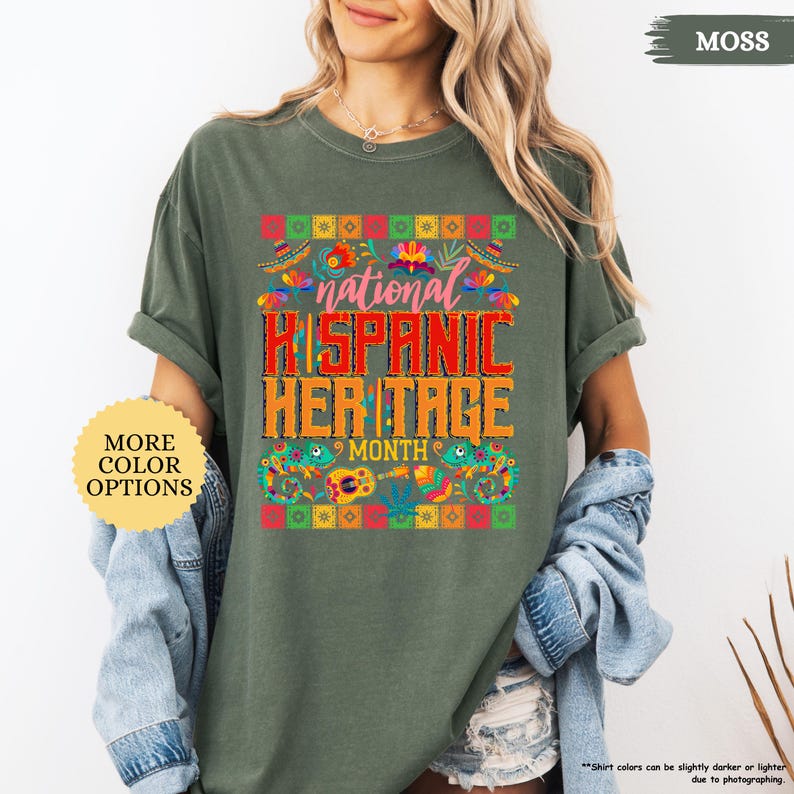 Peut inclure: T-shirt vert mousse avec un graphisme color&eacute; c&eacute;l&eacute;brant le Mois national du patrimoine hispanique. Le motif comprend le texte "National Hispanic Heritage Month" aux couleurs vives, entour&eacute; de motifs floraux et culturels. Le t-shirt a &eacute;galement le texte "More Color Options".