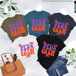 May include: Five t-shirts with the text "PEDS CREW" in a retro font with purple and orange lettering and pink hearts. The shirts are in various colors: olive green, teal, navy blue, white, and black.