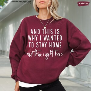 K&ouml;nnte beinhalten: Ein maroonfarbener Pullover mit dem Aufdruck "AND THIS IS WHY I WANTED TO STAY HOME all this, right here." in wei&szlig;.