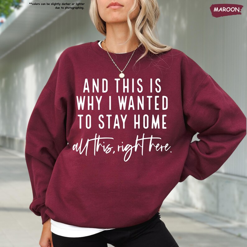 K&ouml;nnte beinhalten: Ein maroonfarbener Pullover mit dem Aufdruck "AND THIS IS WHY I WANTED TO STAY HOME all this, right here." in wei&szlig;.