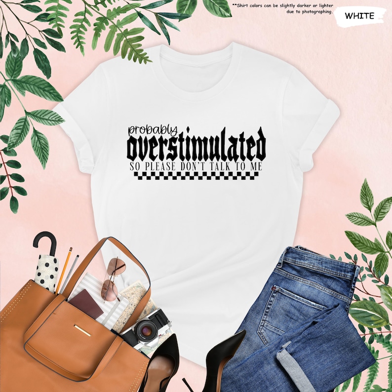 May include: White t-shirt with black text that reads "probably overstimulated so please don't talk to me" with a black and white chequered pattern underneath.
