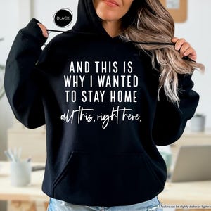 K&ouml;nnte beinhalten: Schwarzer Kapuzenpullover mit dem Text "AND THIS IS WHY I WANTED TO STAY HOME all this, right here." in wei&szlig; gedruckt.