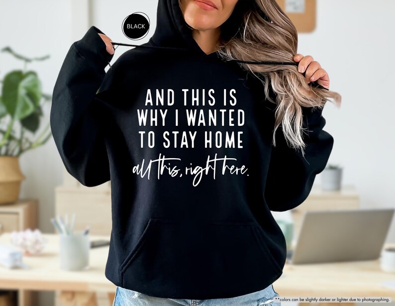 K&ouml;nnte beinhalten: Schwarzer Kapuzenpullover mit dem Text "AND THIS IS WHY I WANTED TO STAY HOME all this, right here." in wei&szlig; gedruckt.